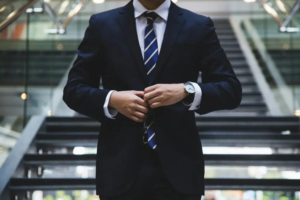 Business professional in a suit adjusting a watch, representing brand strategy return on investment